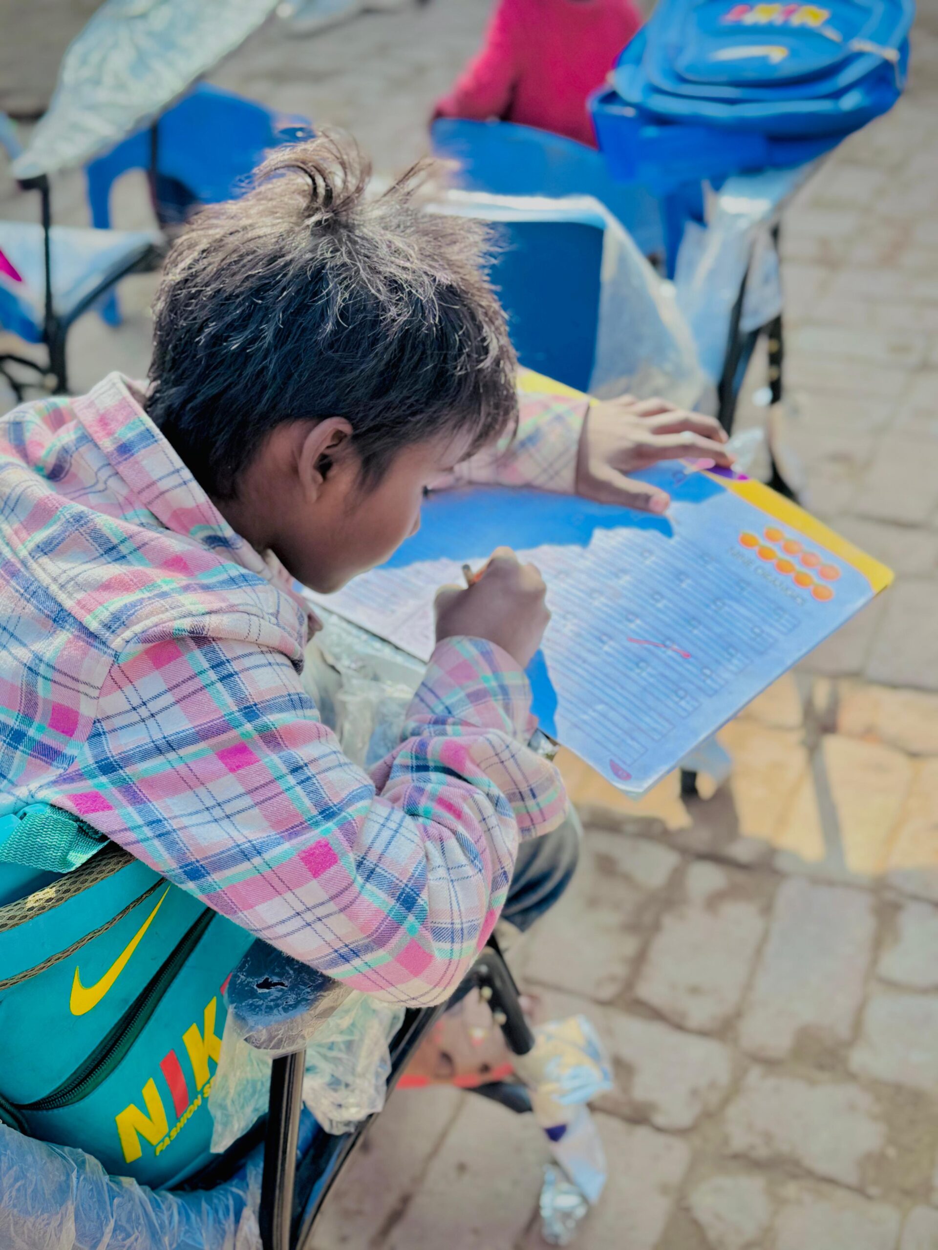 Child studying with a workbook through Kingdom First Mission education support