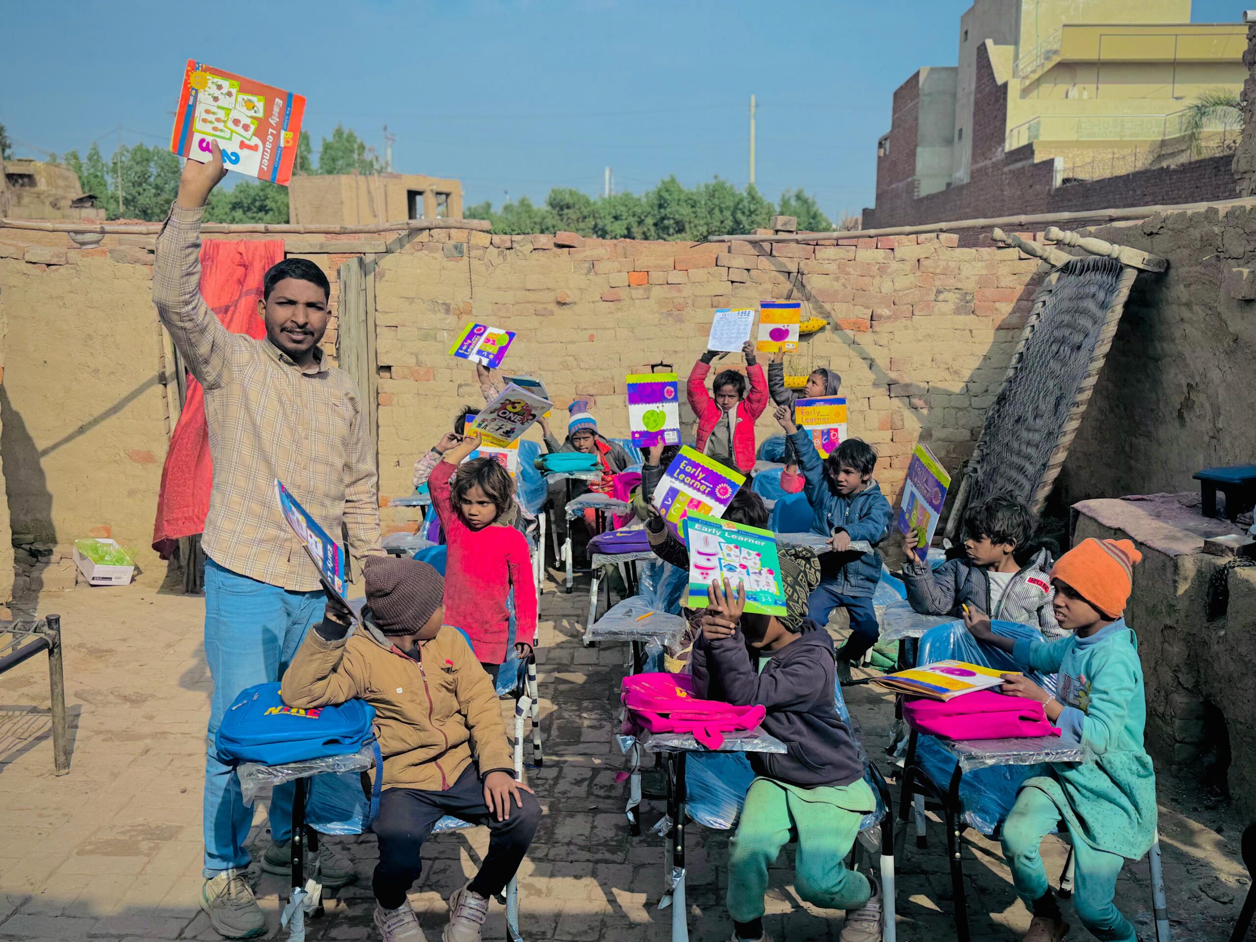 Children holding learning materials during Kingdom First Mission education support