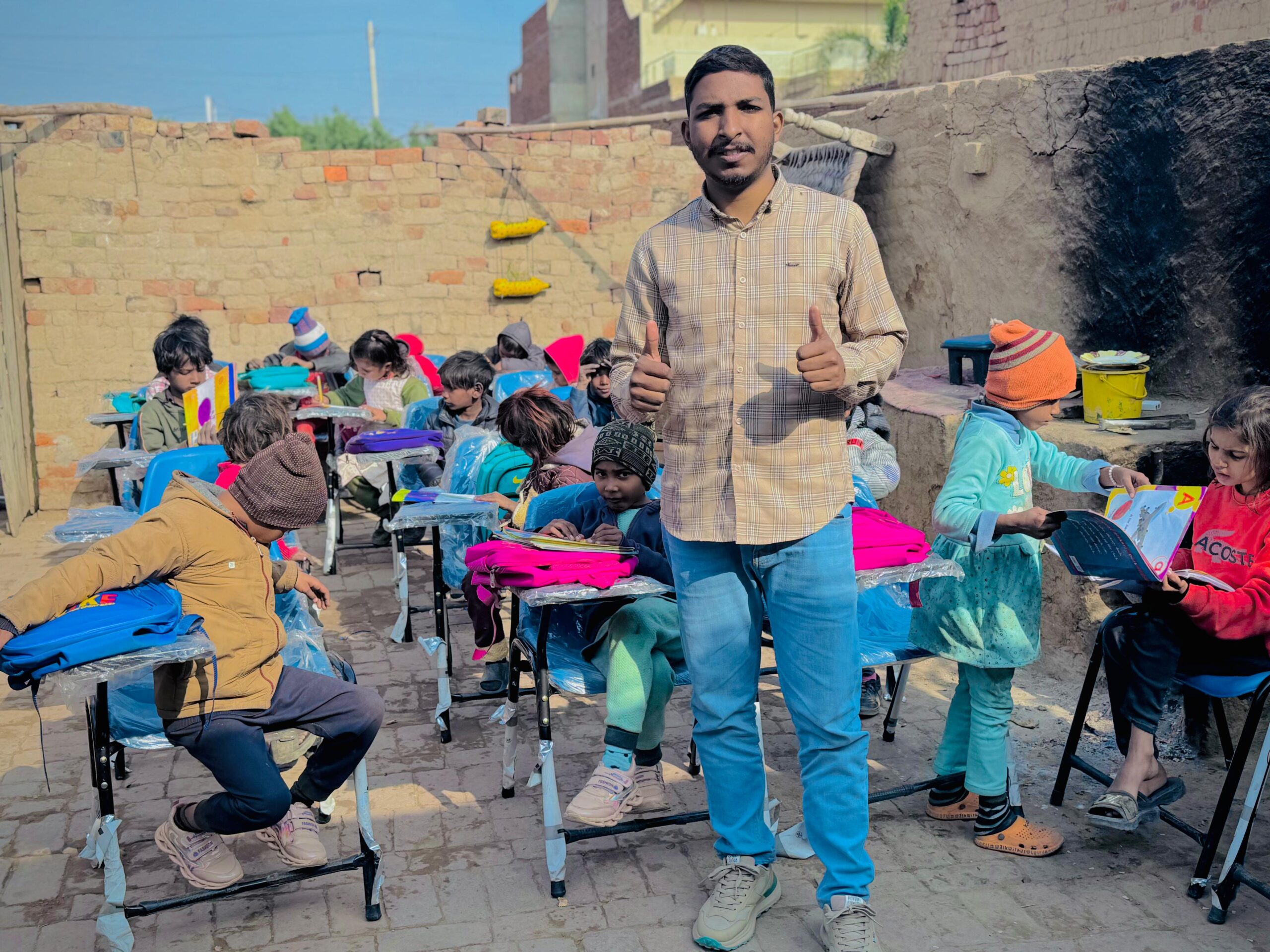 Ministry leader standing with children during outdoor education support in Pakistan