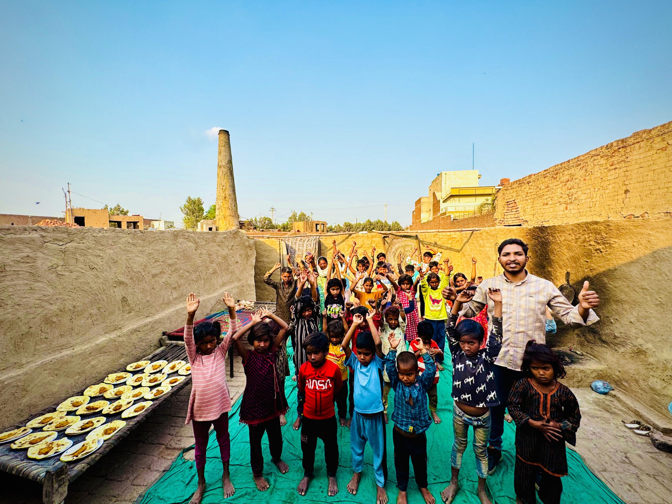 Children gathered for food support in a brick kiln community in Pakistan